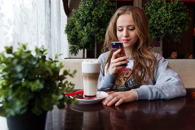 A teen on her phone in a café.