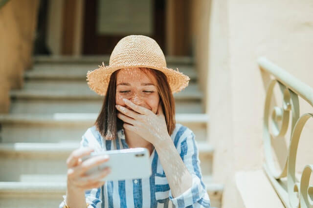 A girl laughing at her phone. 